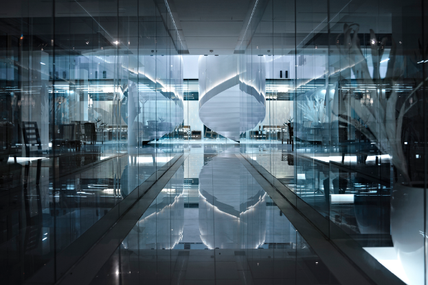 Das Innere eines Gebäudes mit Stühlen, Lampen und Glastüren, mit einem sichtbaren Boden am unteren Rand des Bildes.