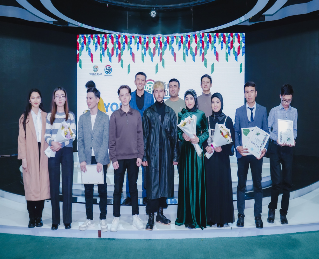 Gruppe von Menschen auf einer Bühne mit Blumensträußen und Urkunden, im Hintergrund ein "Youth Solar Awards 2019"-Schild.