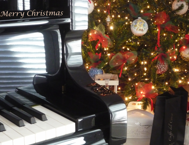 Ein Weihnachtsbaum und ein Piano auf dem Boden mit verschiedenen Gegenständen auf dem Baum.