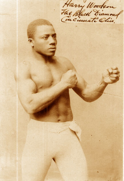 Ein Mann in einem Boxring mit Handschuhen und Shorts, der entschlossen und fokussiert dastand, mit Text überlagert auf dem Bild.