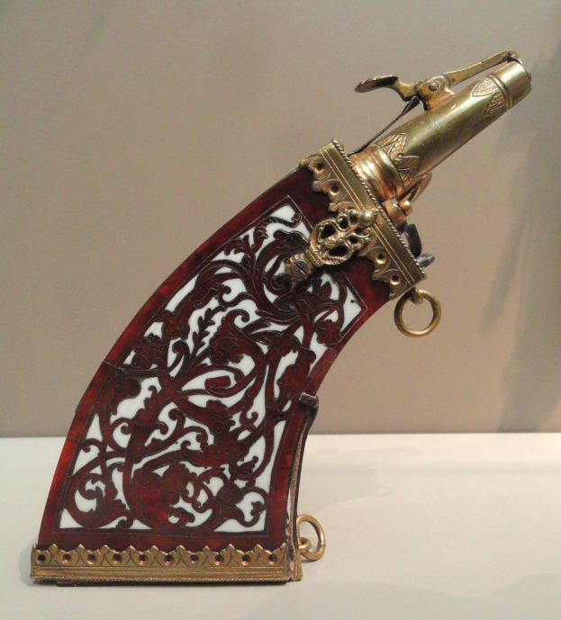 Ein Flintenlauf pistol auf einem Museumsdisplay, auf einem Tisch mit einer Wand im Hintergrund.