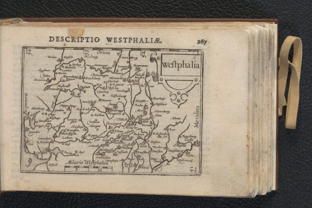 Ein aufgeschlagenes Buch mit einer detaillierten Karte von Westfalen auf einem schwarzen Untergrund.