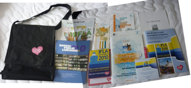 Eine Tasche mit dem Text "Bücherliebhaber" und einigen Büchern auf einem Bett.