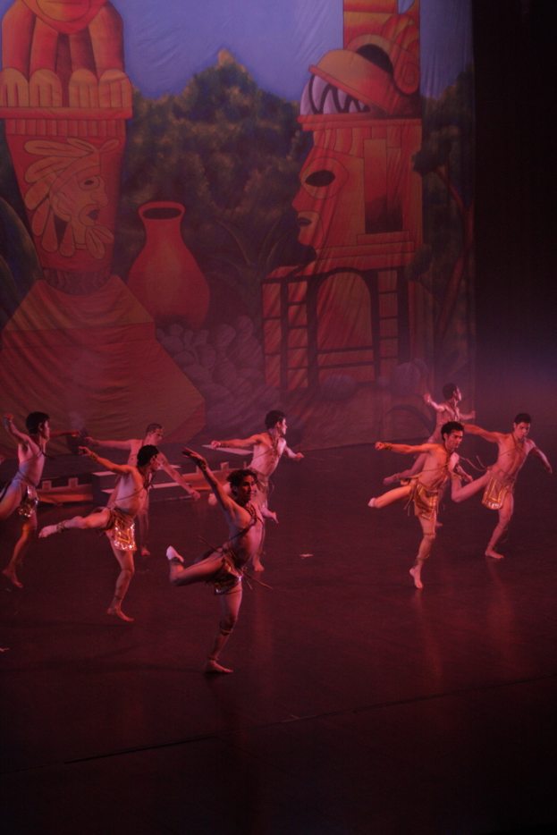 Leute in Kostümen auf einer Bühne mit einem Vorhang im Hintergrund.