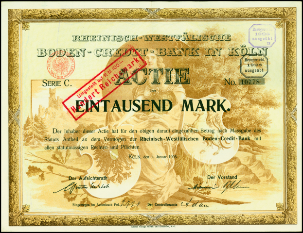 Ein gerahmtes altes deutsches Bankzertifikat mit einem ernsten Mann im Anzug und Krawatte, mit Text und einem Stempel.