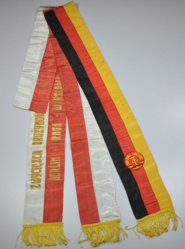 Ein gestreifter Schal mit dem Logo der deutschen Fußballnationalmannschaft auf einer weißen Oberfläche.