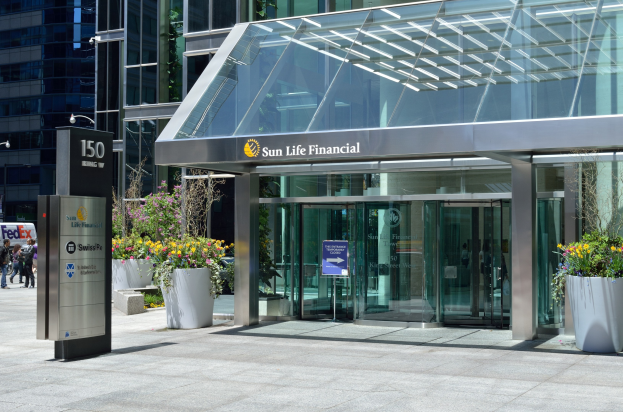 Moderner Glaswand-Sun Life Financial-Gebäude in Toronto mit einer Anzeigetafel, Topfpflanzen, Menschen, einer Straßenlaterne, einer Anzeigetafel und Fahrzeugen auf der Straße.