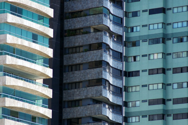 Verschiedene Gebäude in unterschiedlicher Höhe und Gestaltung sind in einer städtischen Umgebung zu sehen.