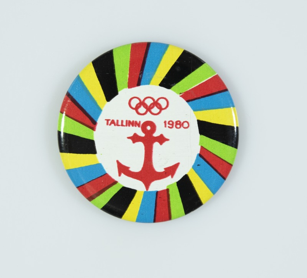Ein weißer Anstecker mit einem Anker und der Aufschrift "Tallinn 1980 Olympische Spiele"