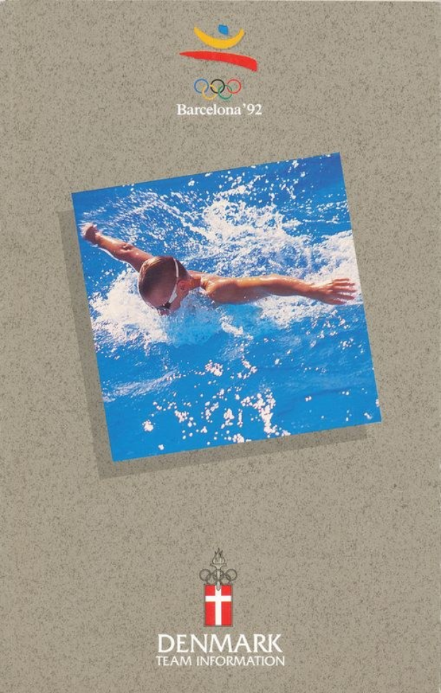 Plakat mit einem Schwimmer in blauer Badehose mit ausgestreckten Armen im Wasser, darunter ein blau-weißes Olympialogo für Barcelona 1992 mit der Aufschrift "Danemark Team Information" und einem hellblauen Himmel mit weißen Wolken.