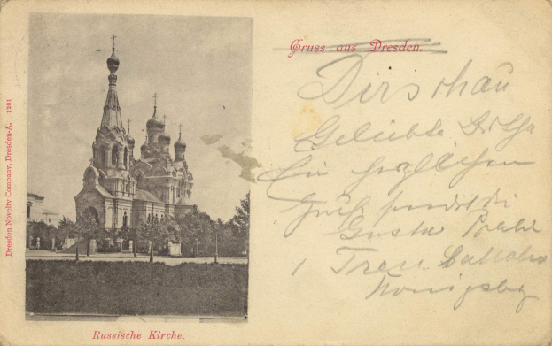 Eine schwarz-weiße Postkarte mit dem Bild der Erlöserkirche auf dem Blutsstein in Dresden, Deutschland, umgeben von Bäumen unter einem klaren blauen Himmel, mit deutschem Text auf der rechten Seite.