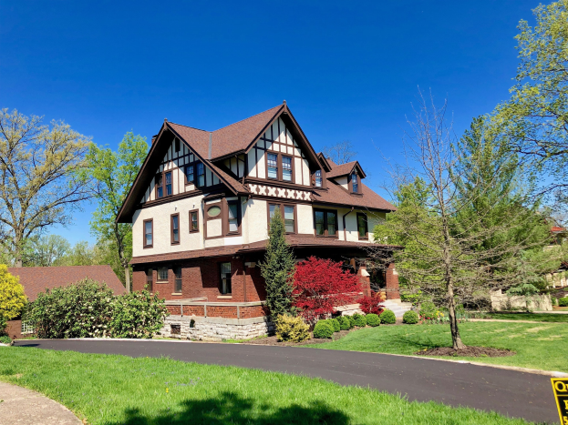 Großes Haus mit zahlreichen Fenstern, umgeben von Bäumen, Pflanzen und Gras, mit einer Straße im Vordergrund und Himmel im Hintergrund, gelegen in Detroit, Michigan.