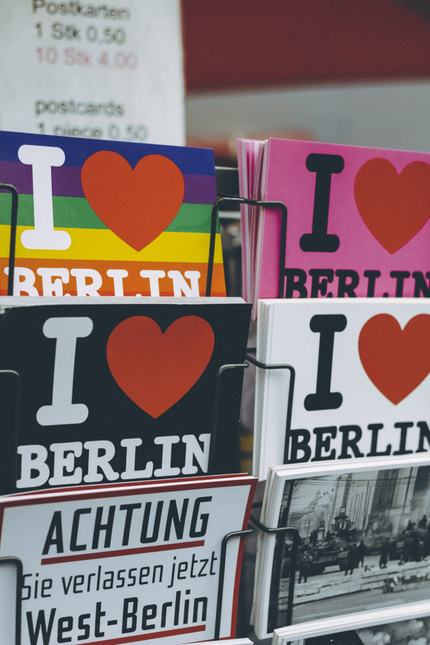 Ein Gestell mit Büchern und Postern mit der Aufschrift "Ich liebe Berlin" vor einem leicht unscharfen, träumerischen Hintergrund.