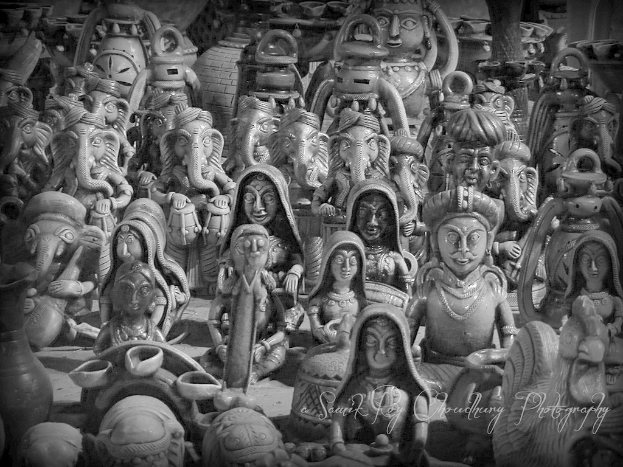 Mehrere Ganesha-Statuen werden neben Figuren von Frauen und Männern gezeigt.