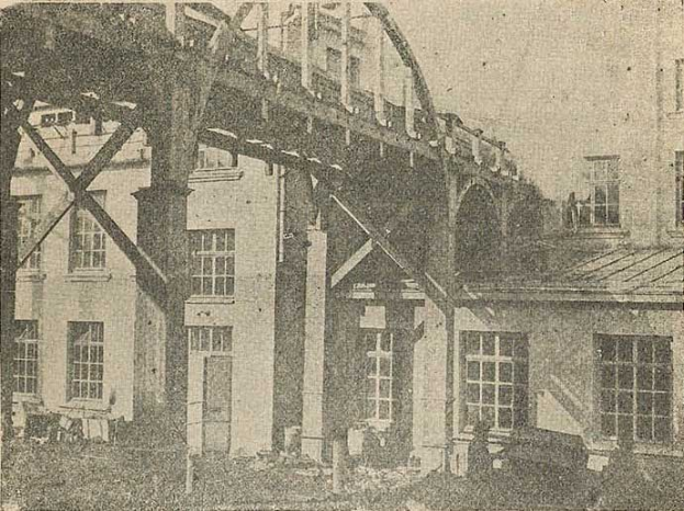 Schwarzes und weißes Foto eines im 1890er Jahren errichteten Gebäudes mit Fenstern, Säulen und einem Himmelhintergrund, darunter die Bildunterschrift "1890er Jahre - Bau einer Eisenbahnbrücke".