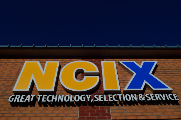 Ziegelgebäude mit einer Tafel, auf der "NCIX Great Technology, Selection & Service" steht.