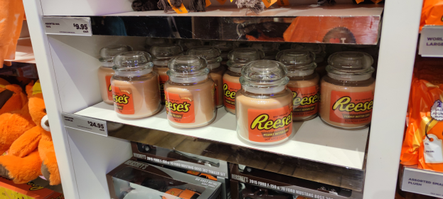 Ein Regal voller verschiedener Süßigkeiten, darunter Glasbehälter mit Etiketten, Verpackungen, Spielzeug und andere Gegenstände.