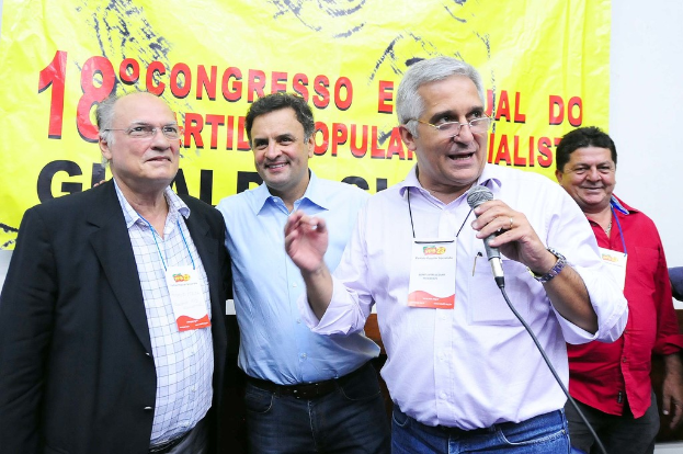 Ein Mann spricht in ein Mikrofon vor einem gelben Vorhang mit der Aufschrift "18. Grad Kongress o".