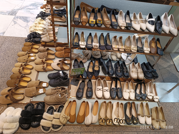 Ein Schaufenster voller verschiedener Schuharten auf Ständern, jeweils mit einem Preisschild versehen.